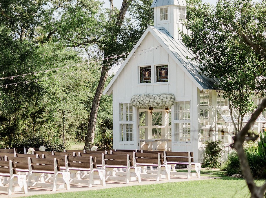 Aerial View of a little white chapel in the woods with lush green trees and grass - Houston Wedding Venue